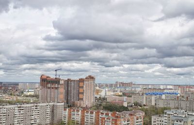 Aerial view of cityscape against dramatic sky