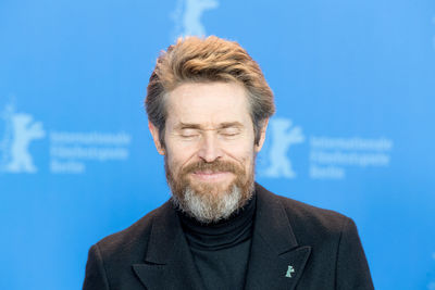 Close-up of mature man against blue sky