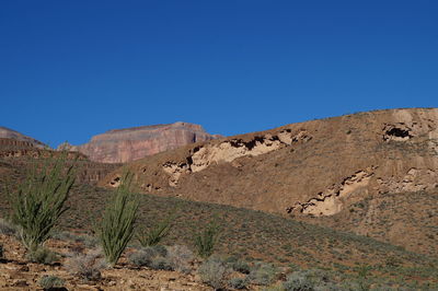 Scenic view of mountains against clear blue sky