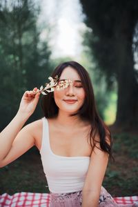 Portrait of a smiling young woman sitting outdoors