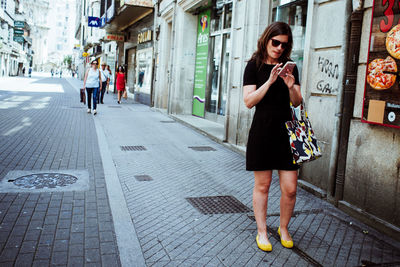 Full length of woman standing on street in city