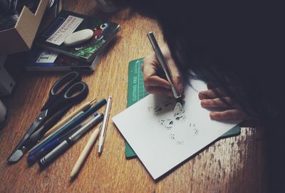 High angle view of boy writing on book