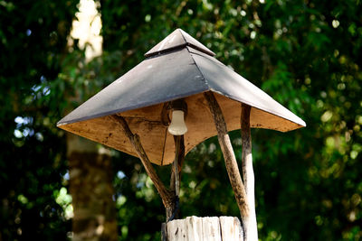 Close-up of birdhouse on wooden post
