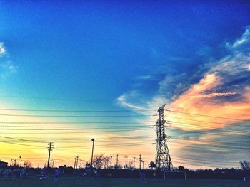 Silhouette of electricity pylon against sky during sunset