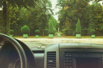 Road amidst trees seen through car windshield