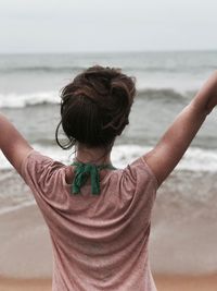 Rear view of woman standing at beach