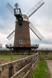 Traditional windmill on field against sky