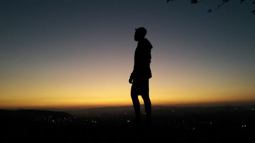 Silhouette man standing against sky during sunset