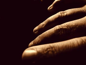 Close-up of human hand against black background