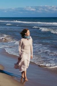 Full length of woman on beach against sky