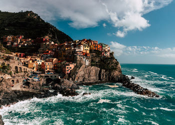 Scenic view of sea by buildings against sky