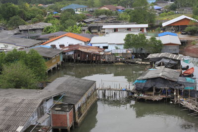 High angle view of houses by lake against buildings