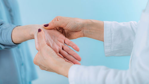 Doctor doing carpal tunnel syndrome test with a senior woman.