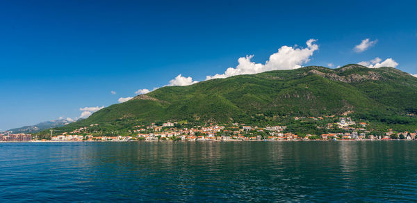 Scenic view of sea and mountains against blue sky