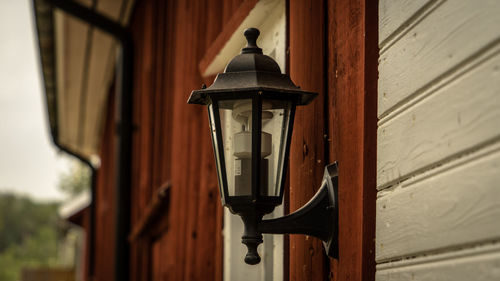 Low angle view of lamp hanging by building