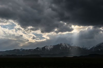 Scenic view of mountains against storm clouds