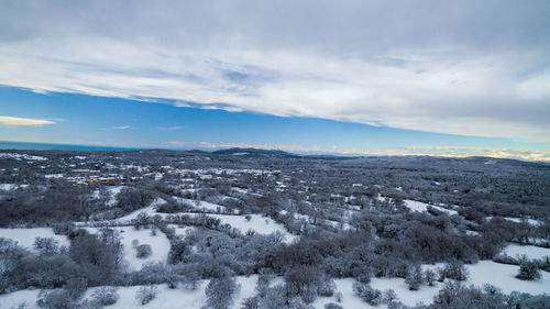 Aerial view of snowcapped landscape against sky