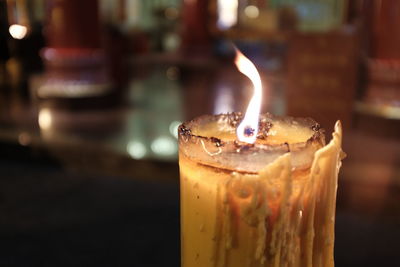 Close-up of burning candle on table