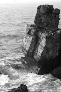 Rock formation in sea against sky