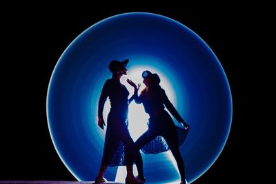 Couple kissing against black background