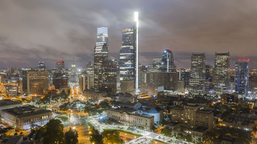 Illuminated buildings in city against sky at night