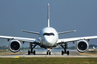 Airplane on airport runway against clear sky