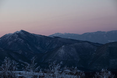 Scenic view of snowcapped mountains against sky at sunset