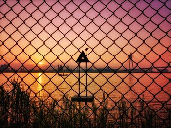 Silhouette person by sea against sky during sunset