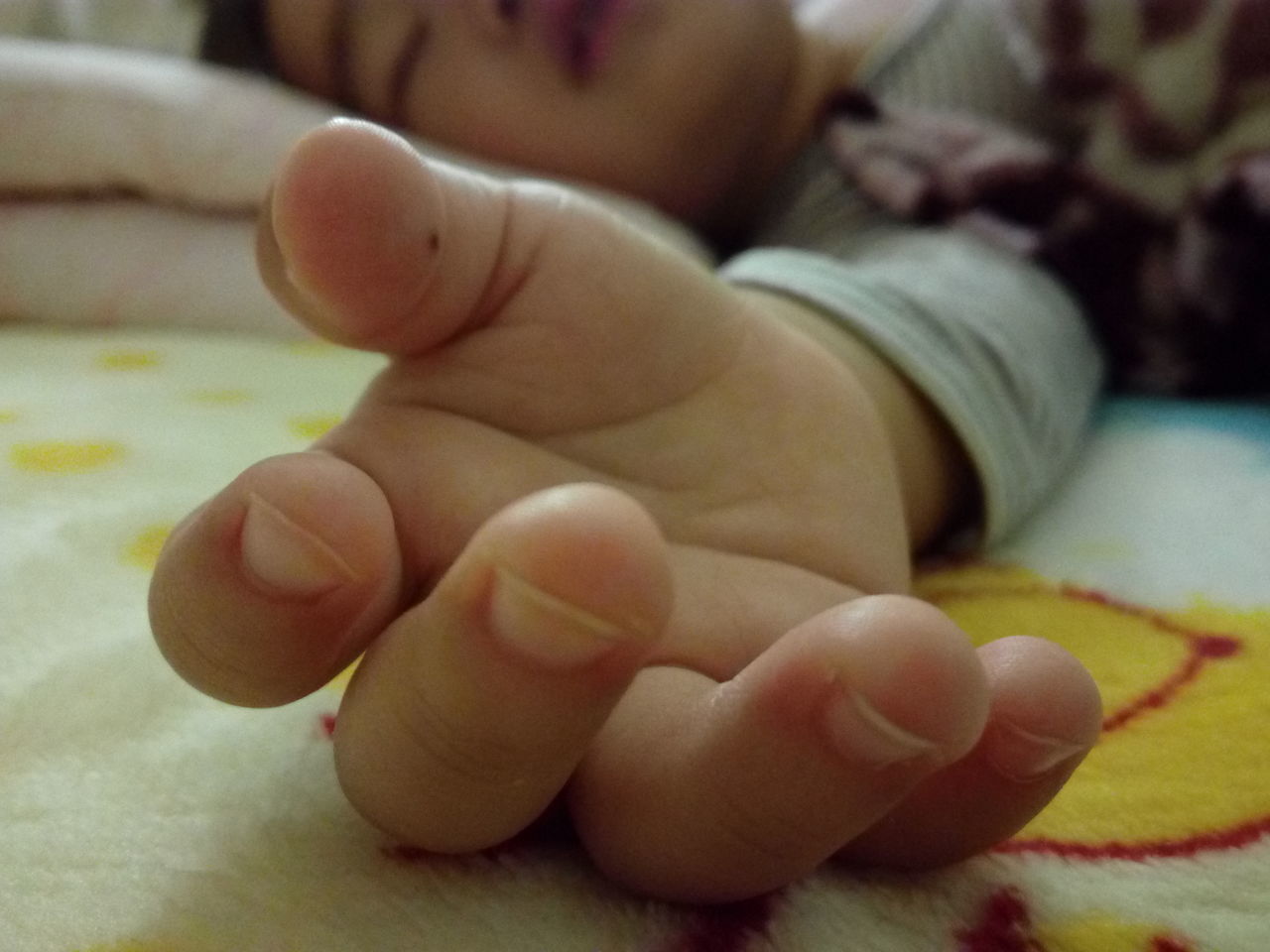 CLOSE-UP OF BABY LYING ON BED