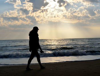 Full length of man standing on beach during sunset