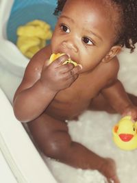 High angle view of cute baby boy sitting in bathtub