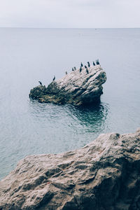 Aerial view of rocks in sea against sky