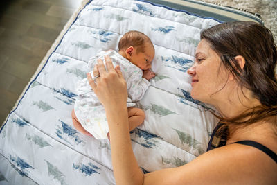 Midsection of mother and daughter on bed