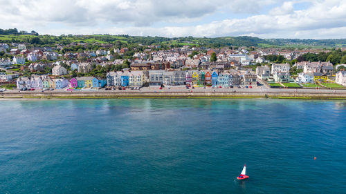 High angle view of townscape by sea against sky