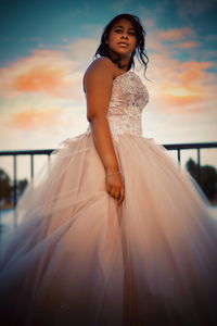 Happy woman standing on field against sky