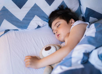 High angle view of boy sleeping on bed