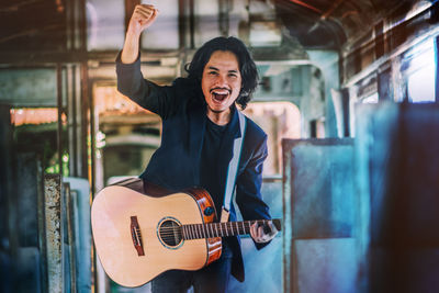 Full length portrait of a young man playing guitar