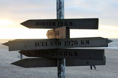 Road sign against cloudy sky