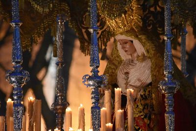 Lit candles by virgin mary sculpture in church