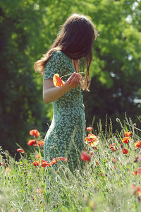 Woman with arms raised on field