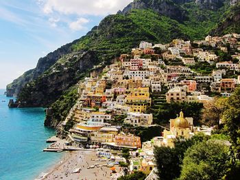 Buildings on mountain by sea