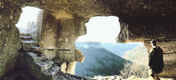 Rear view of people standing in cave