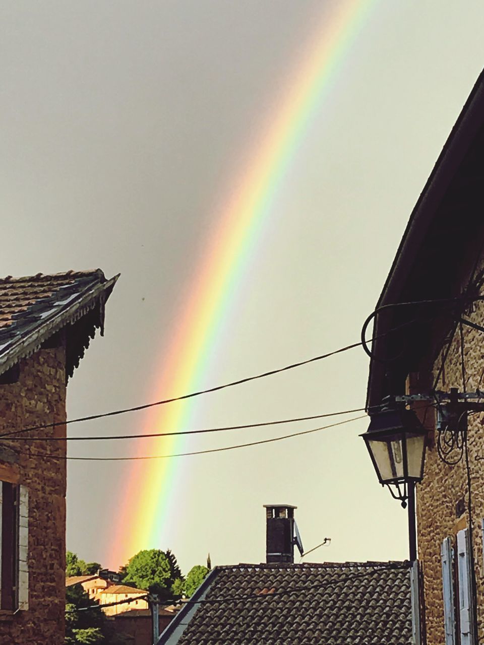 LOW ANGLE VIEW OF RAINBOW OVER BUILDINGS IN CITY