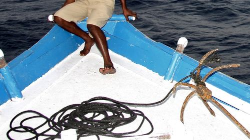 Low section of man fishing in sea