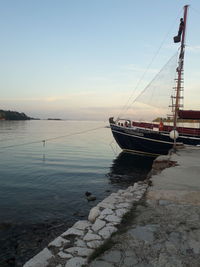 Sailboats moored in sea against clear sky