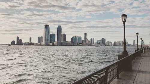 Modern buildings by sea against sky in city