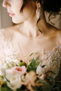 Midsection of bride holding bouquet