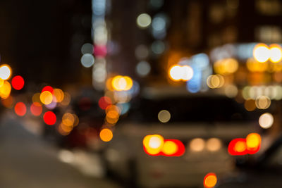 Defocused image of illuminated city street at night