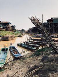 Fishing boats moored at harbor against buildings