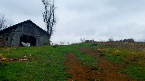 Abandoned house on field against sky